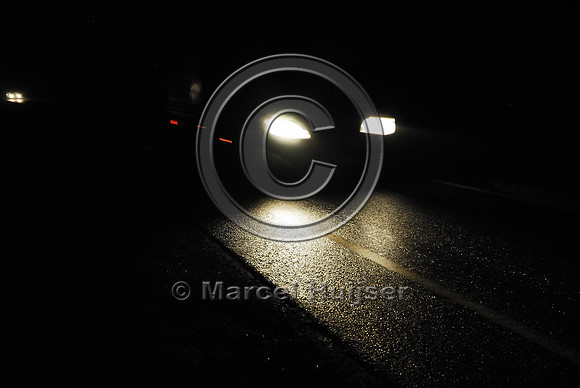 Car with headlights passing at nights, The Netherlands