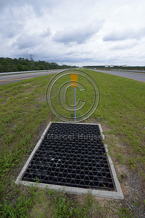 Opening (with bridge grate cover) in median to allow light and moisture in the wildlife underpass, Hwy 331, Hwy 83 near Freeport, Florida, USA