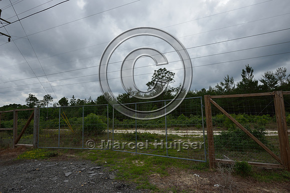Locked gate where access road crosses a wildlife fence line, Hwy 331, Hwy 83 near Freeport, Florida, USA