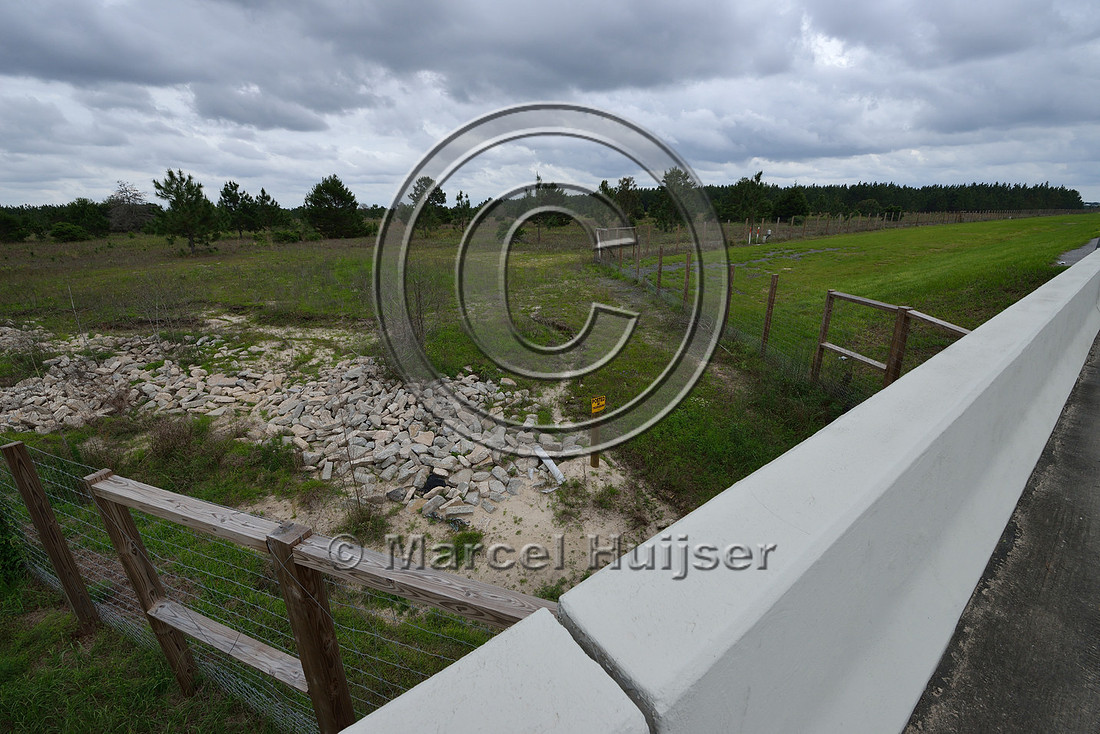 Wildlife fence (smaller mesh size towards bottom) funnels wildlife towards wildlife underpass, Hwy 331, Hwy 83 near Freeport, Florida, USA
