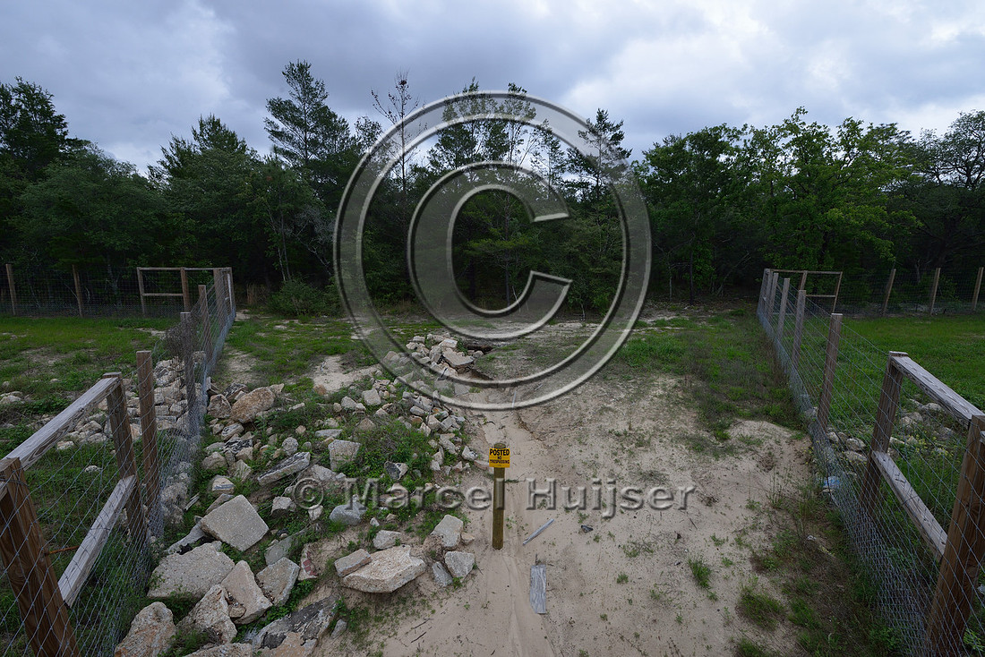 Sign, posted, no trespassing, and erosion at entrance and exit of wildlife underpass, Hwy 331, Hwy 83 near Freeport, Florida, USA