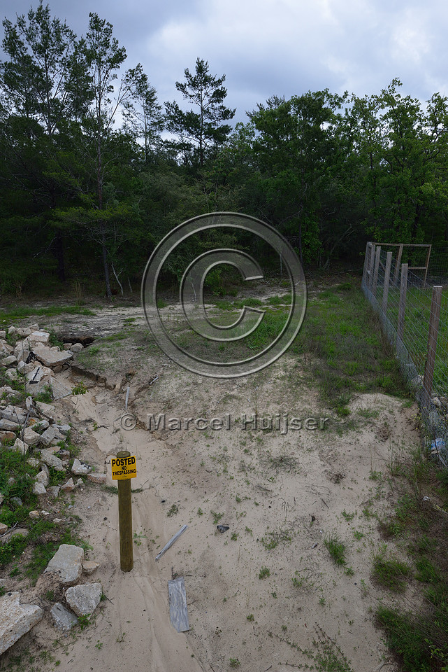 Sign, posted, no trespassing, and erosion at entrance and exit of wildlife underpass, Hwy 331, Hwy 83 near Freeport, Florida, USA