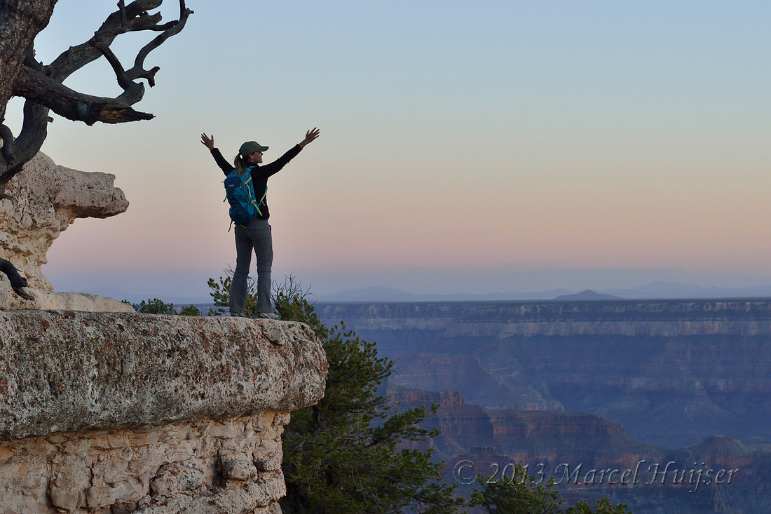 Southwest landscapes: Young woman at rocky outcrop overlooking Grand Canyon, Bright Angel Trail, Grand Canyon National Park, Arizona, USA