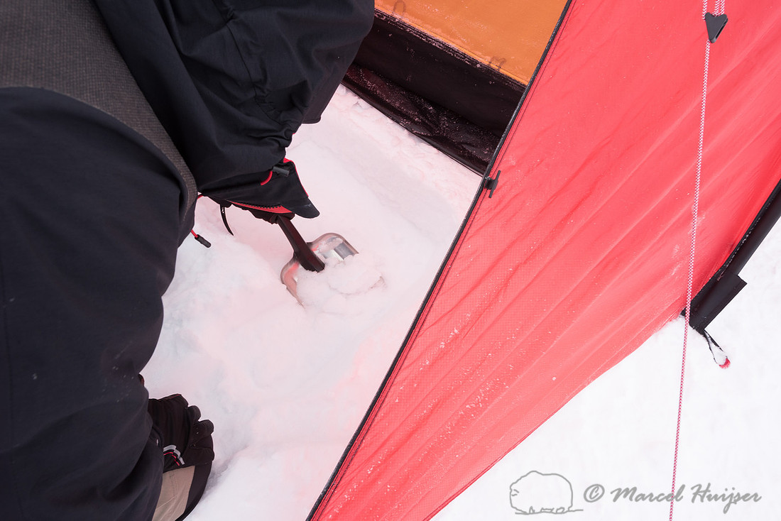Niels Kooijman digs a pit for cooking in the snow, Dovrefjell, N