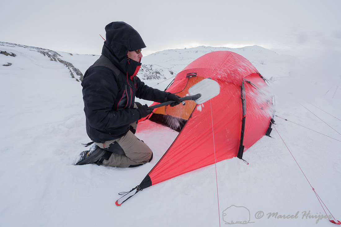 Niels Kooijman digs a pit for cooking in the snow, Dovrefjell, N