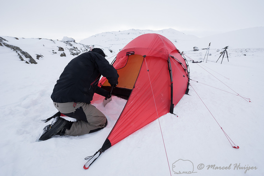 Niels Kooijman digs a pit for cooking in the snow, Dovrefjell, N