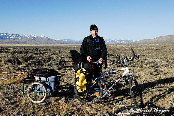 Marcel Huijser and his bicycle and trailer packed with photo and camping gear near a sage grouse (Centrocercus urophasianus) lek, Montana, USA