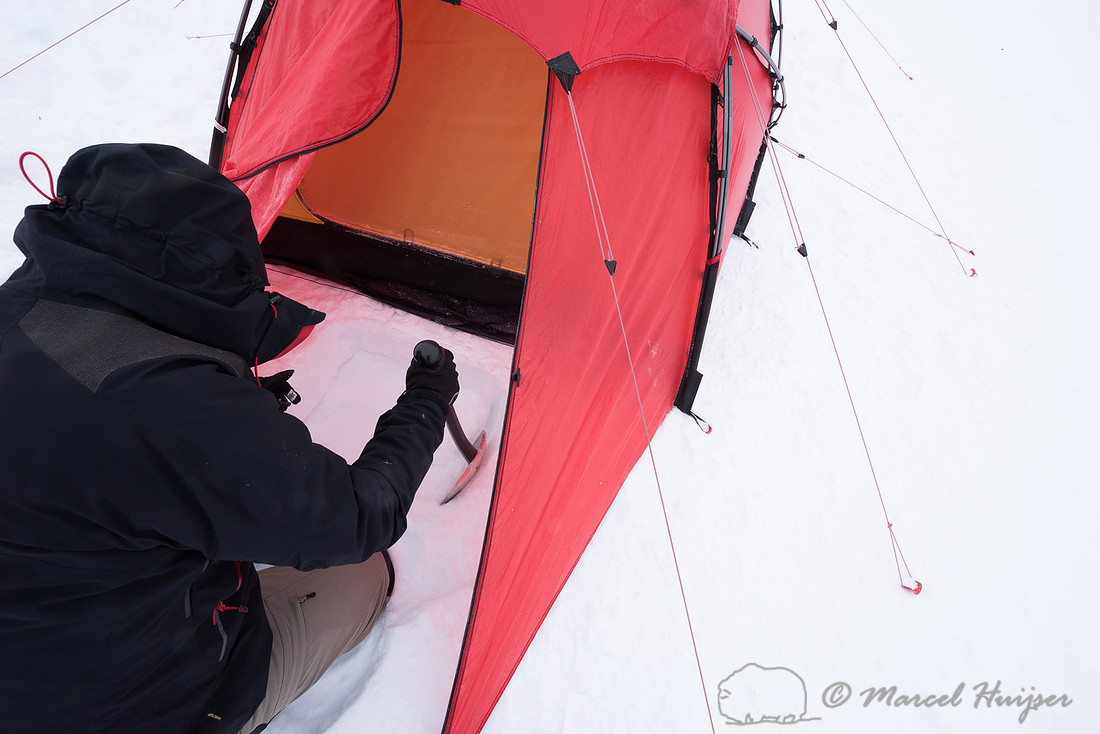 Niels Kooijman digs a pit for cooking in the snow, Dovrefjell, N