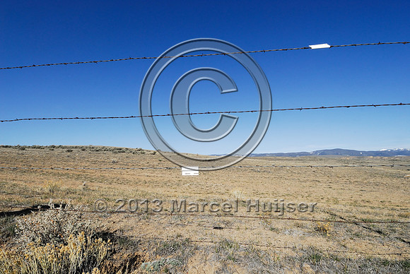 Livestock fence with markers for sage grouse, Montana, USA