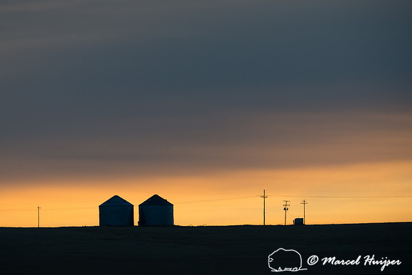 Silos silhouetted during sunrise, Montana, USA