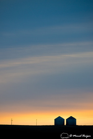 Silos silhoutted during sunrise, Montana, USA