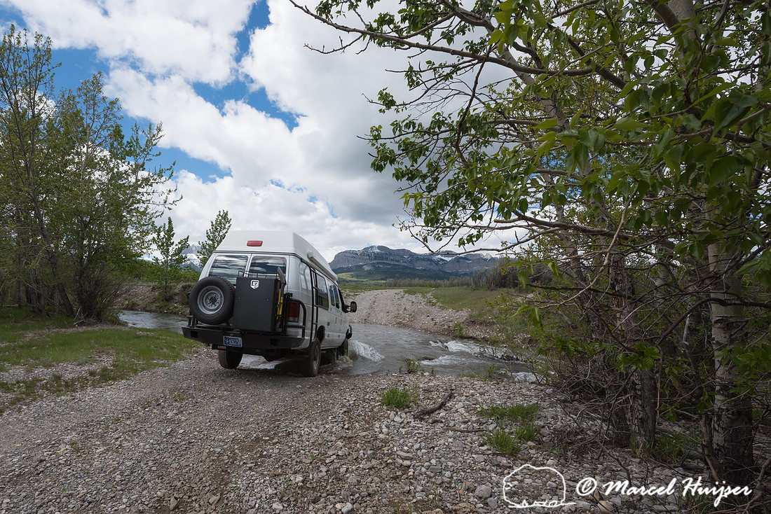 Our Ford E350 4x4 camper van on dirt road, crossing a creek, Mon