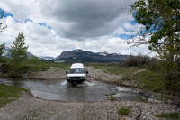 Our Ford E350 4x4 camper van on dirt road, crossing a creek, Mon