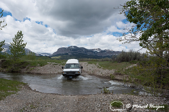 Our Ford E350 4x4 camper van on dirt road, crossing a creek, Mon
