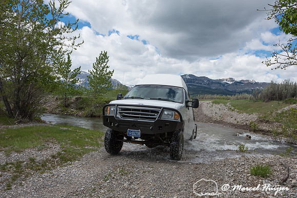 Our Ford E350 4x4 camper van on dirt road, crossing a creek, Mon
