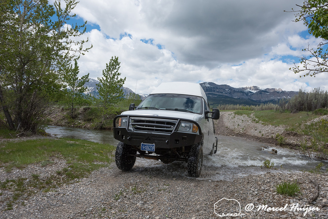 Our Ford E350 4x4 camper van on dirt road, crossing a creek, Mon