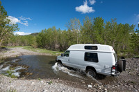 Our Ford E350 4x4 camper van on dirt road, crossing a creek, Mon