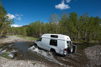 Our Ford E350 4x4 camper van on dirt road, crossing a creek, Mon