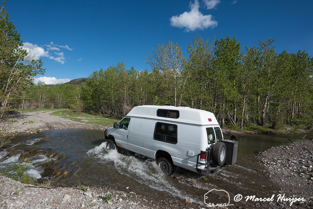 Our Ford E350 4x4 camper van on dirt road, crossing a creek, Mon