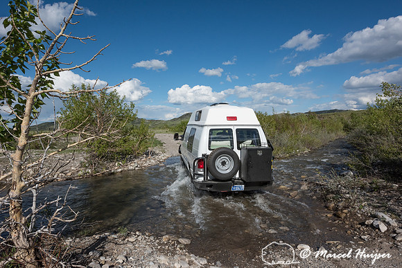 Our Ford E350 4x4 camper van on dirt road, crossing a creek, Mon