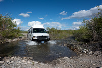 Our Ford E350 4x4 camper van on dirt road, crossing a creek, Mon