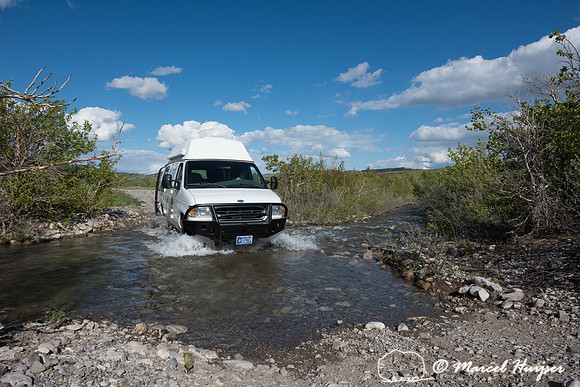 Our Ford E350 4x4 camper van on dirt road, crossing a creek, Mon