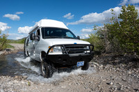 Our Ford E350 4x4 camper van on dirt road, crossing a creek, Mon