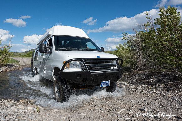 Our Ford E350 4x4 camper van on dirt road, crossing a creek, Mon