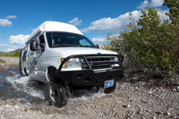 Our Ford E350 4x4 camper van on dirt road, crossing a creek, Mon
