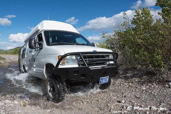 Our Ford E350 4x4 camper van on dirt road, crossing a creek, Mon