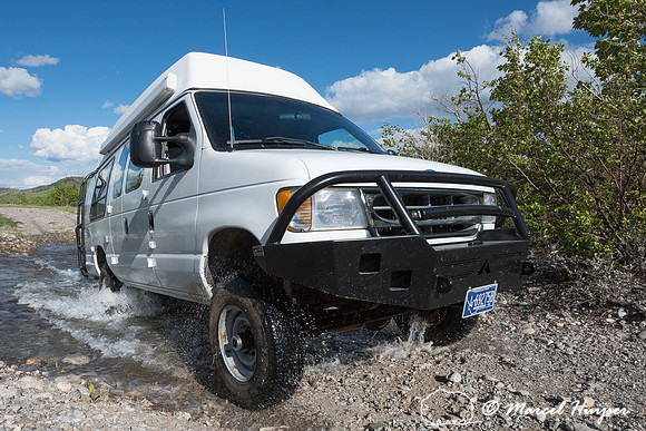 Our Ford E350 4x4 camper van on dirt road, crossing a creek, Mon