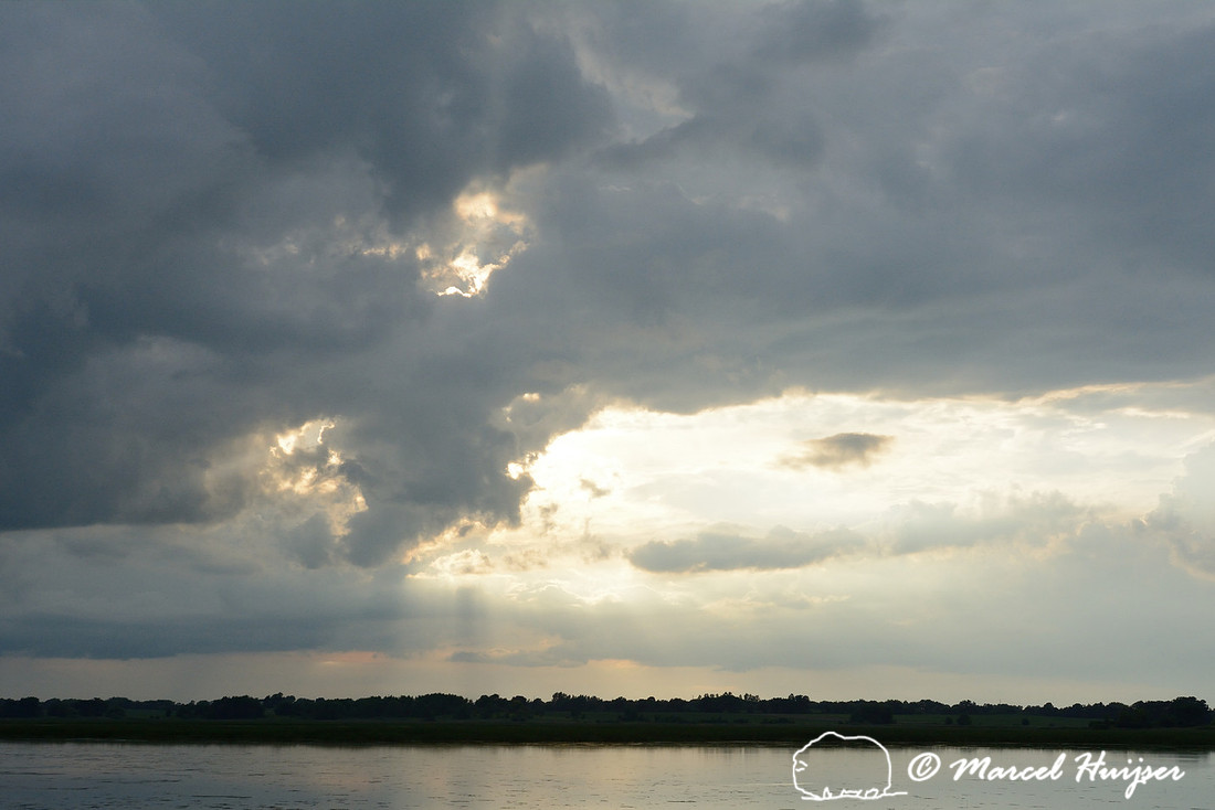 Sun shining through clouds in evening, Horicon Marsh National Wildlife Refuge, Wisconsin, USA