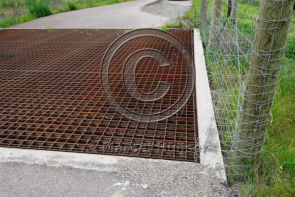 Fence bulbouts  at a wildlife guard installed to make it more difficult for deer (Odocoileus spp.) to walk across the concrete ledge and access the highway, near Ravalli, Montana, USA
