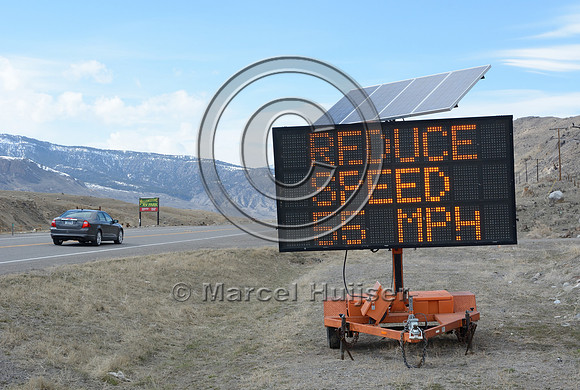 Wildlife warning sign, variable message sign, wildlife on roadway, reduce speed 55 MPH, next 12 to 15 miles, Montana. USA