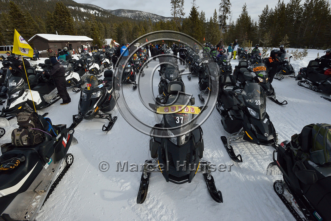 Lines of snowmobiles at Madison junction parking area, Yellowstone National Park, Wyoming, USA