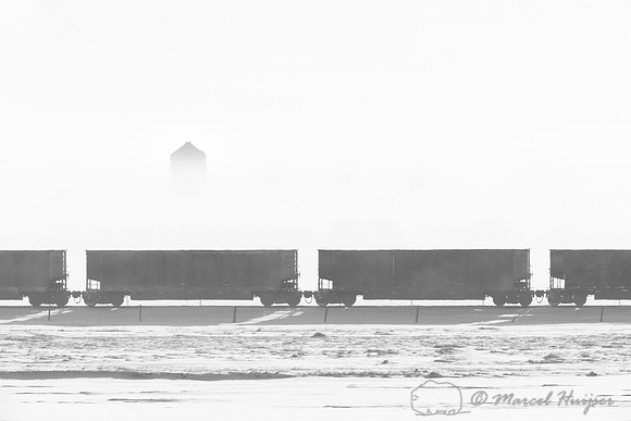 Cargo train and silo in fog, Montana, USA