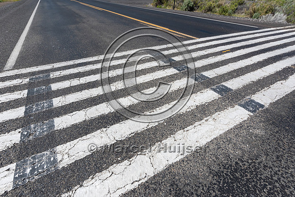 White stripes painted on the road surface meant to imitate a cat