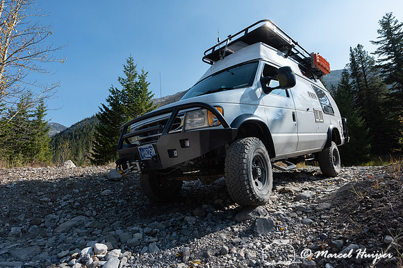 Camper van crossing dry creek, Rocky Mountains, Montana