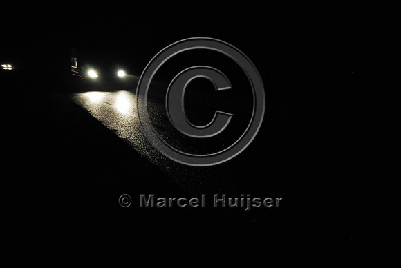 Car with headlights passing at nights, The Netherlands