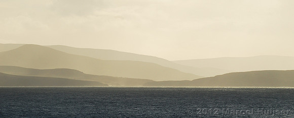 Hills and mountains on the Kerry peninsula with sun and clouds over Dingle Bay, Ireland