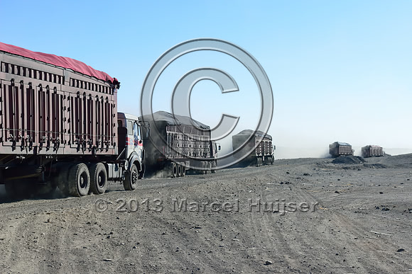 Coal trucks departing the settlement of Tsagaan khad (White Rock), north of Gashuun-Sukhait, Gobi, Mongolia