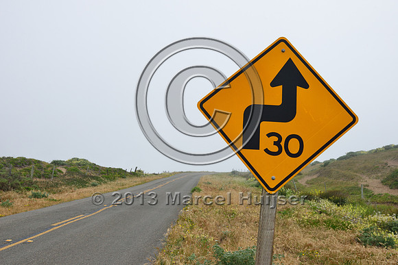 Warning sign curvy road, 30 m per hour, Reyes National Seashore, California, USA