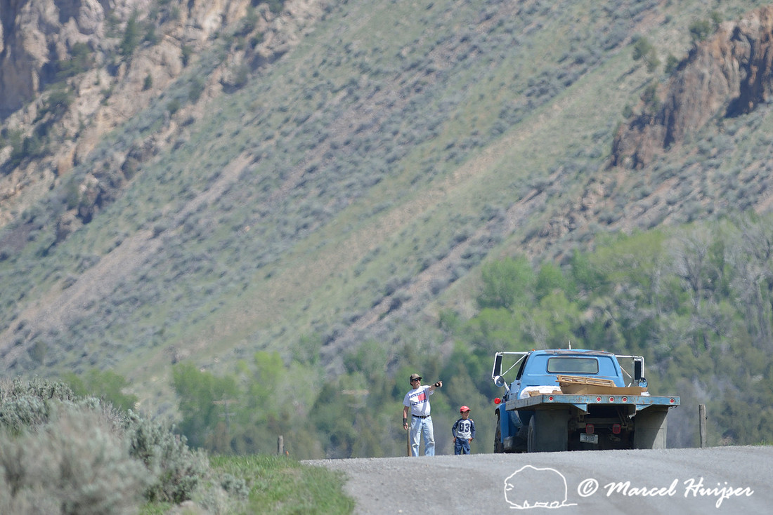 Man and boy next to flatbed pickup on dirt road, Montana, USA