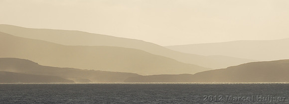 Hills and mountains on the Kerry peninsula with sun and clouds over Dingle Bay, Ireland
