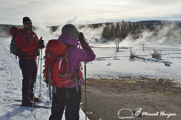 Skiers looking at thermal features, Yellowstone National Park, Wyoming, USA