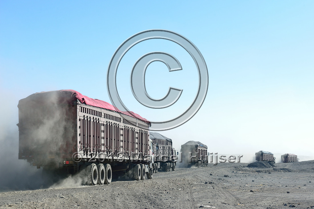 Coal trucks departing the settlement of Tsagaan khad (White Rock), north of Gashuun-Sukhait, Gobi, Mongolia