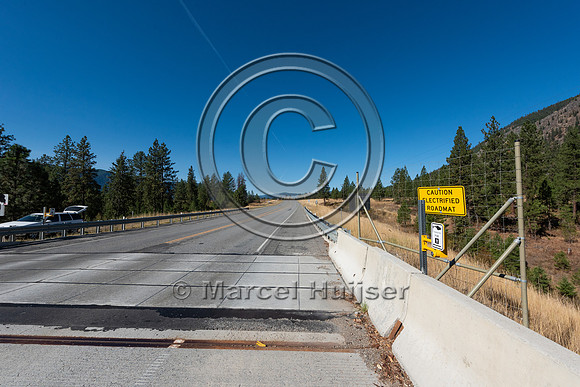 Electified barrier for large mammals embedded in the travel lane